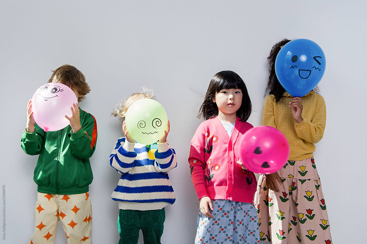 Four kids with balloons in studio.