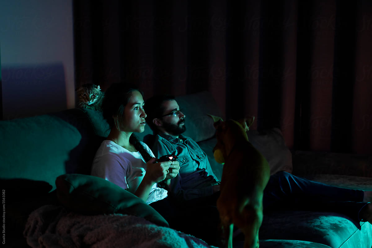 Happy couple playing videogames at night having fun