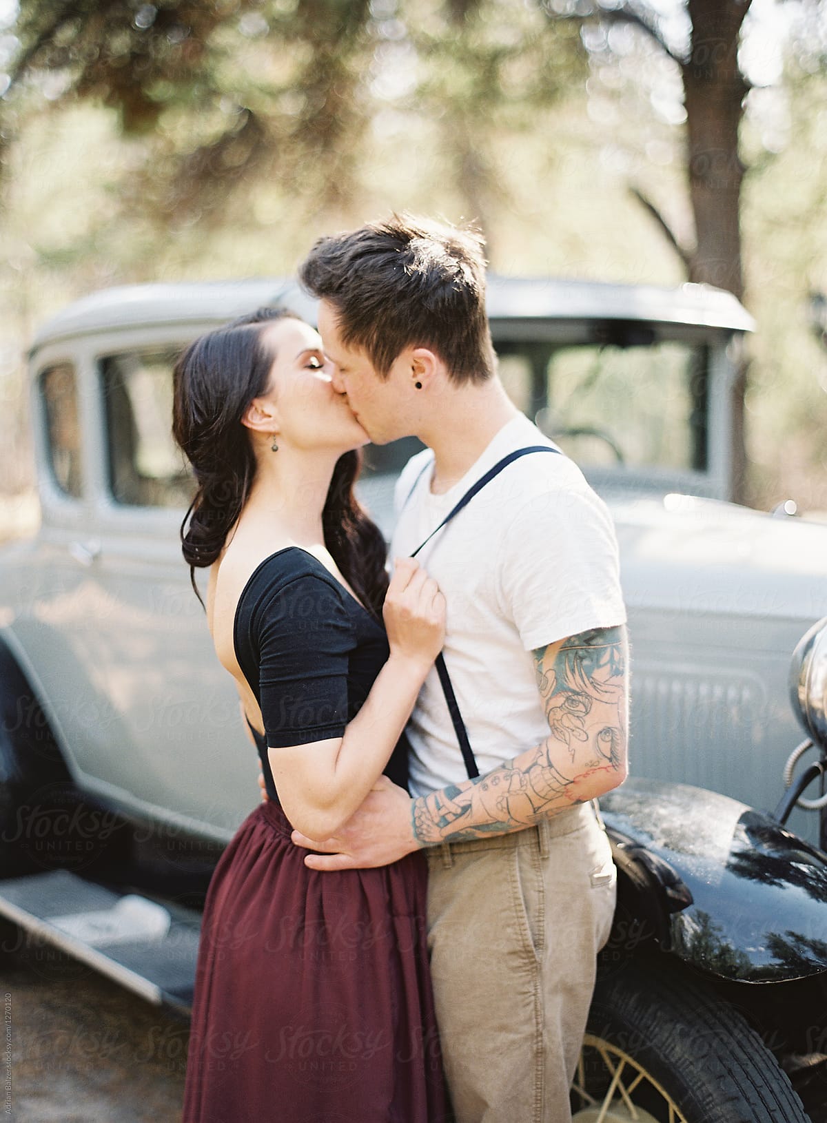 Couple kisses by antique car