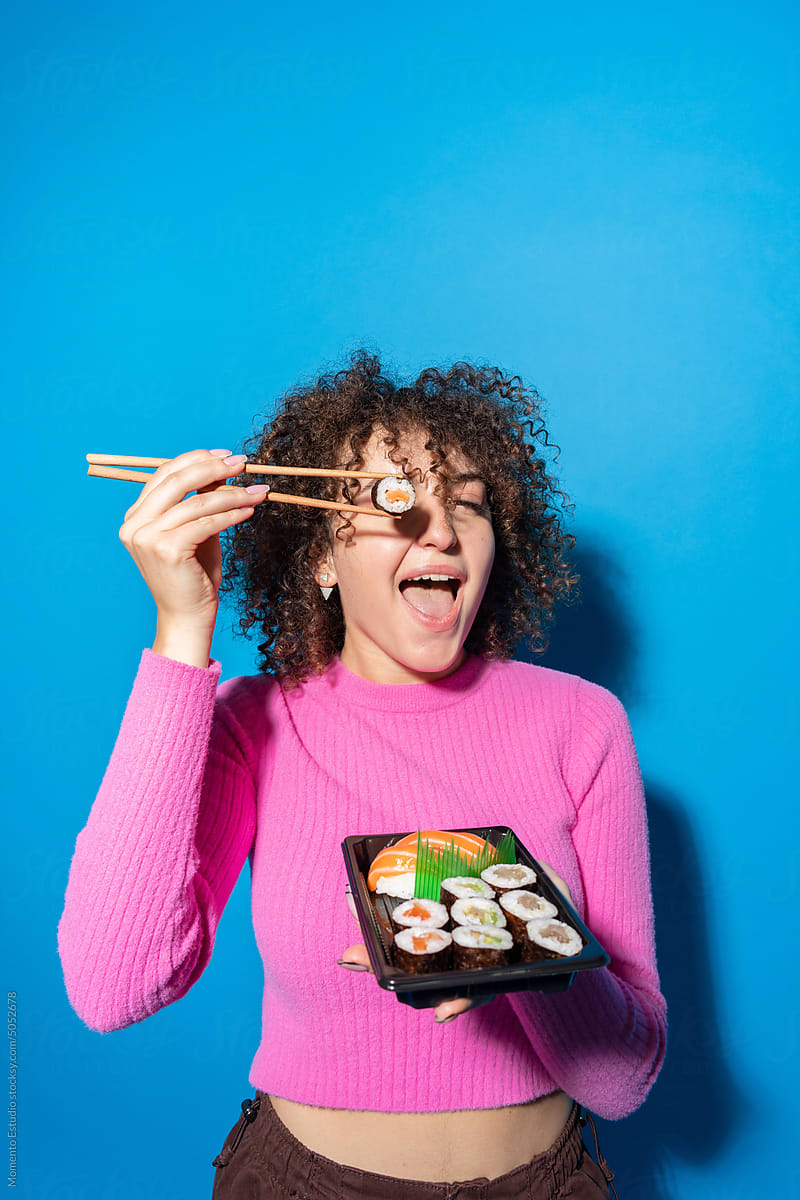 Woman covering eye with takeaway sushi