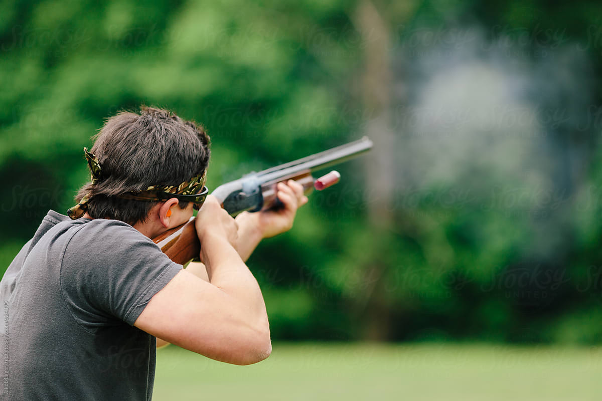 Man firing his shotgun while skeet shooting