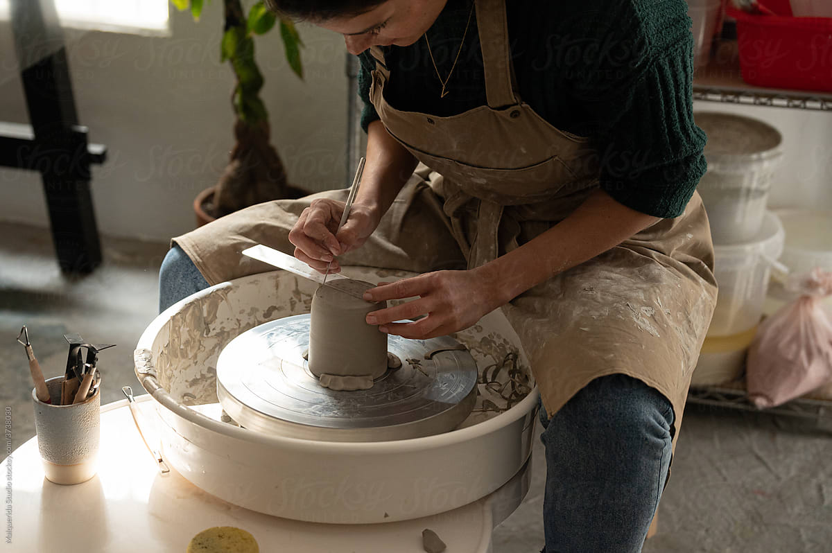 Faceless artisan working with a pottery lathe