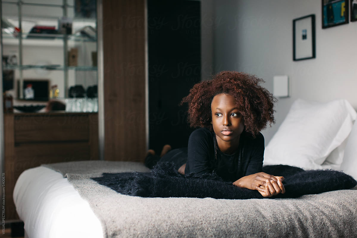 Indoor Portrait Of Beautiful Black Female Model Lying On Hotel Bed By 