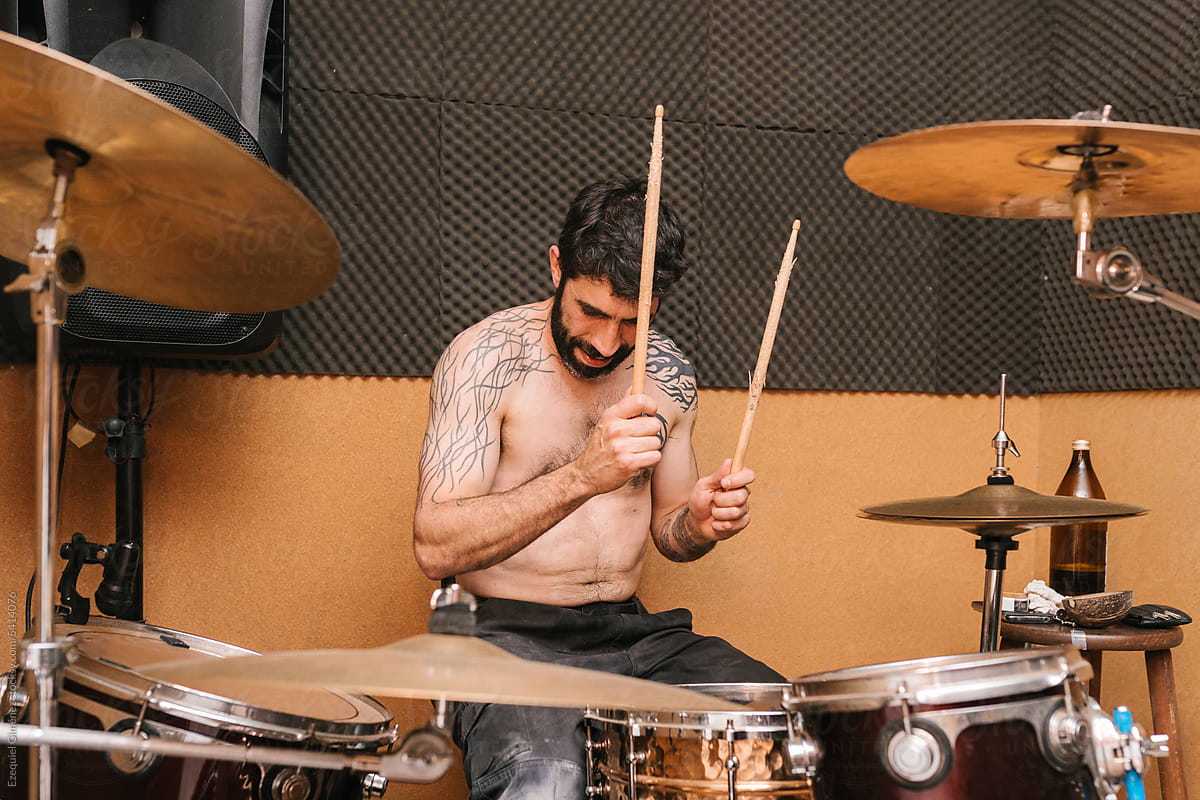 Cool bearded drummer playing drums during rehearsal