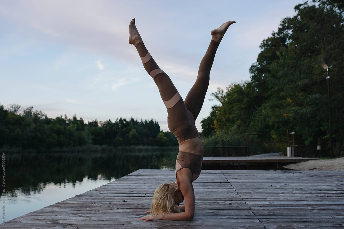Blonde Woman Doing Yoga Handstand outside