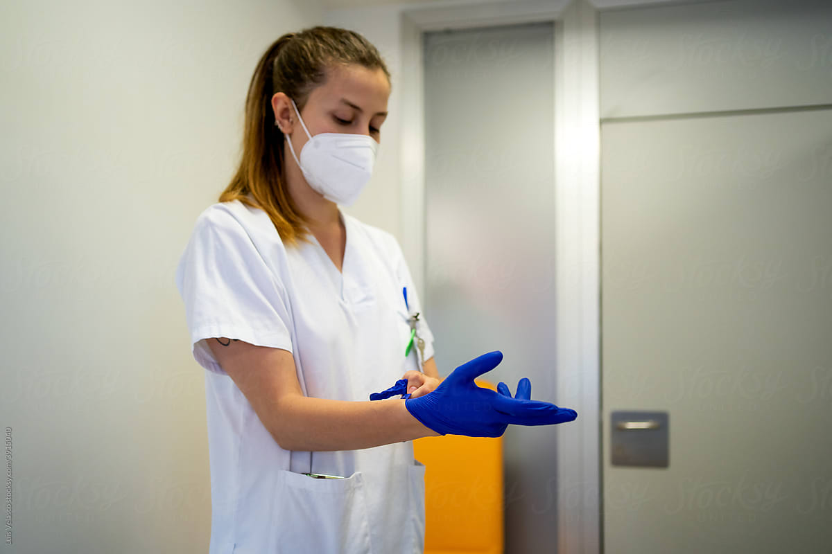 Nurse Putting On The Protective Gloves In The Hospital.