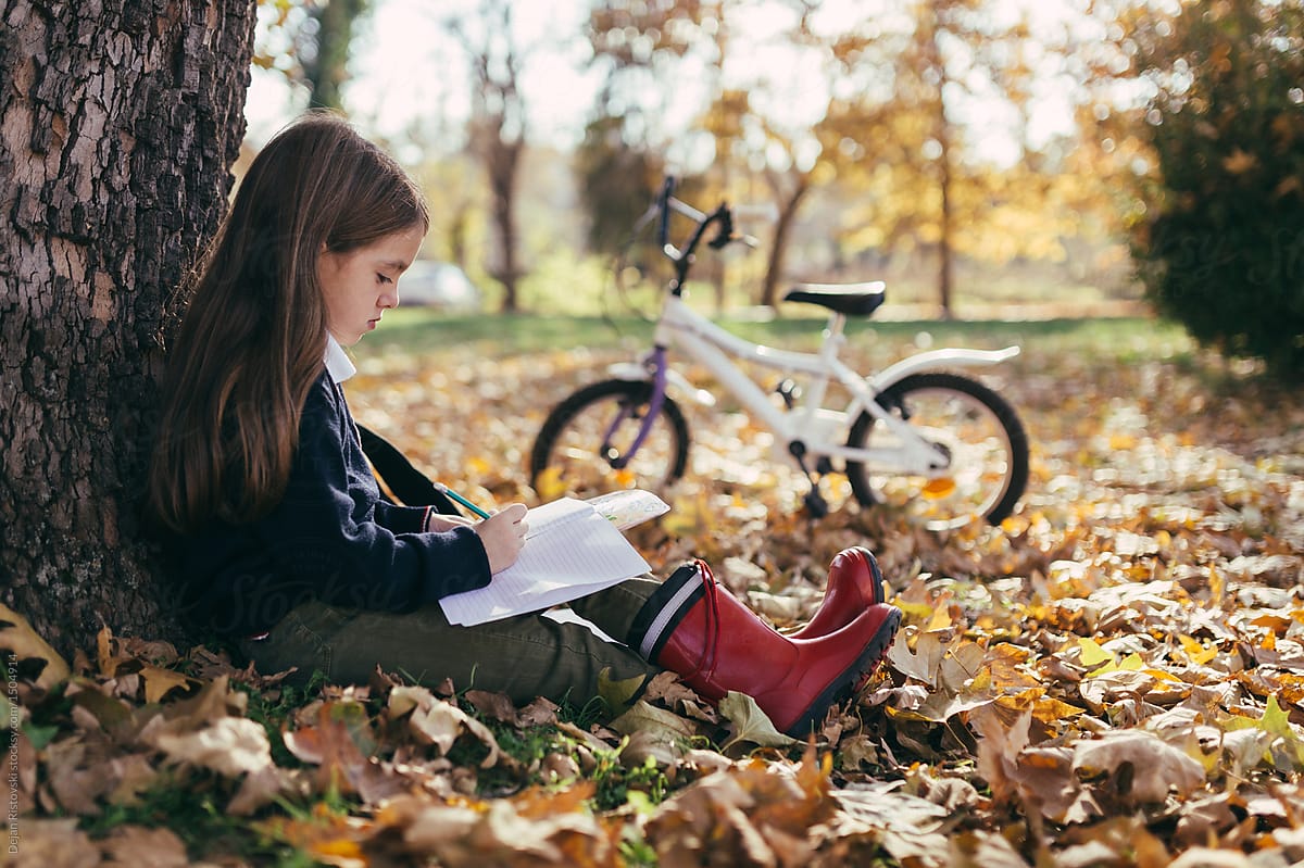 Young girl studying in the park.