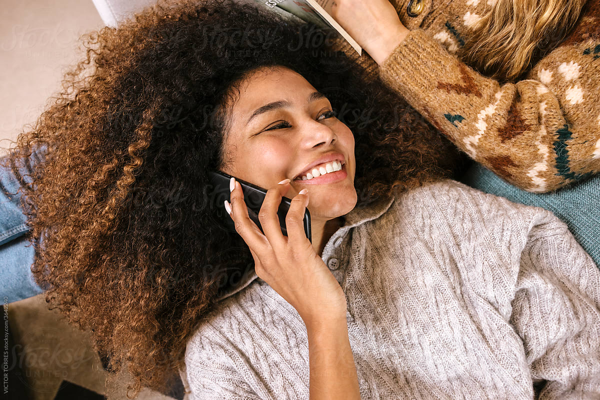 Cheerful black woman speaking on smartphone