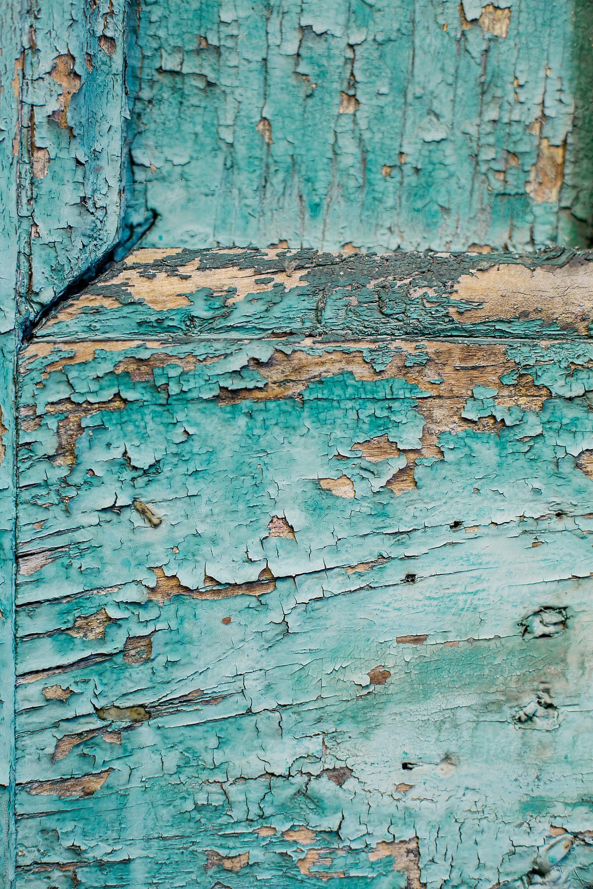 Blue paint flaking off from wooden surface