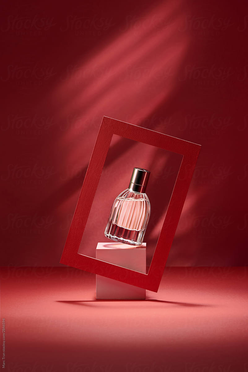 Still life of a perfume over red background