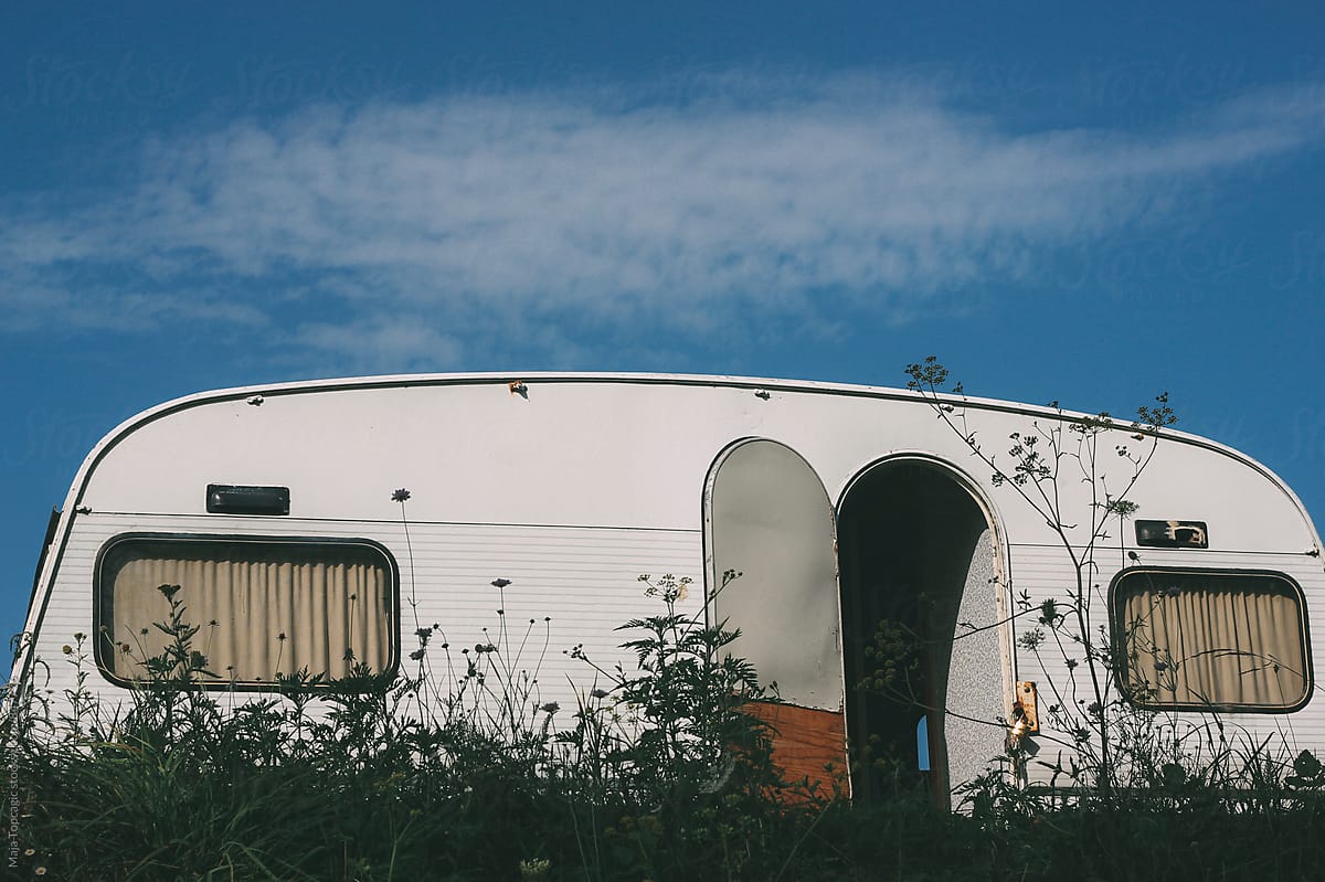 White retro camp house parked on a meadow