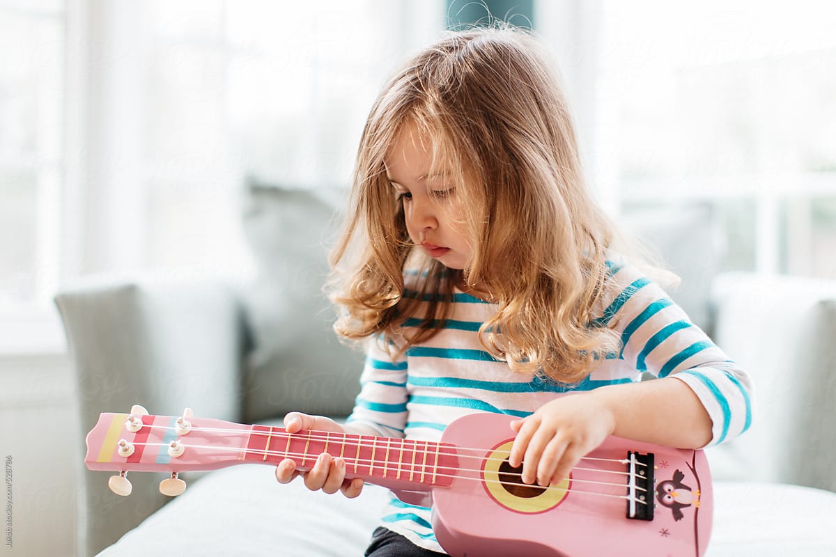 Cute toddler playing a toy guitar