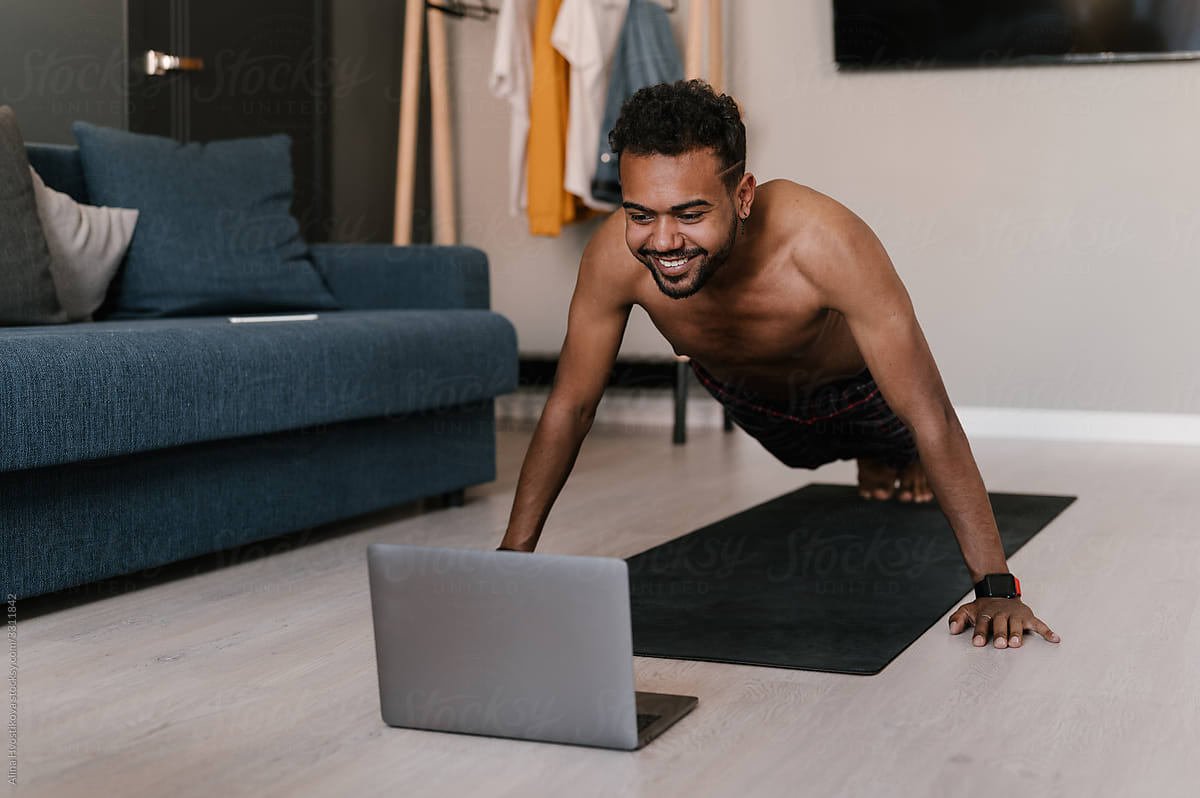 Happy black athlete during online workout at home