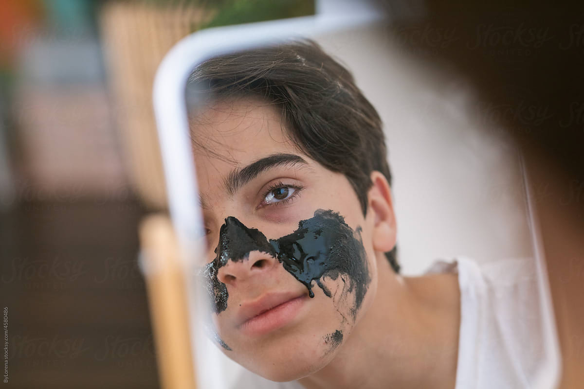 Teen boy with mask reflected at mirror