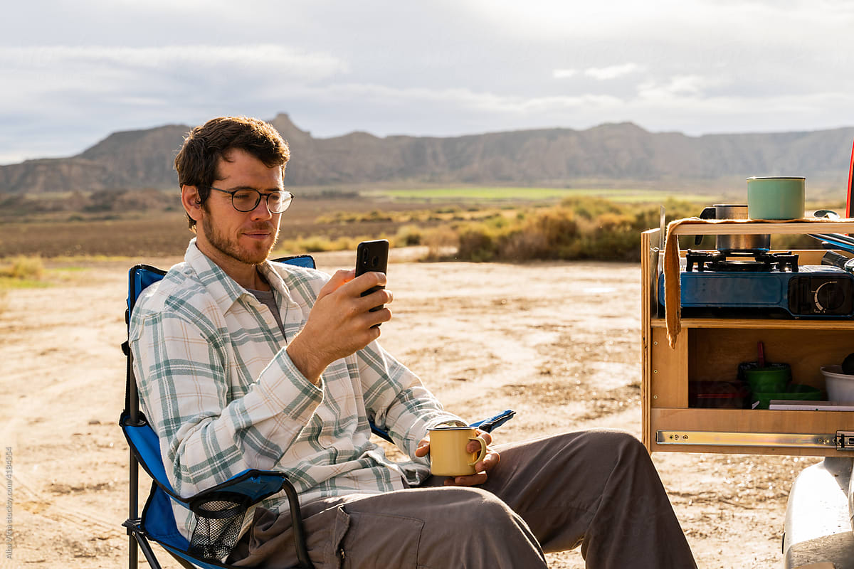 Man using phone while having coffe outdoors