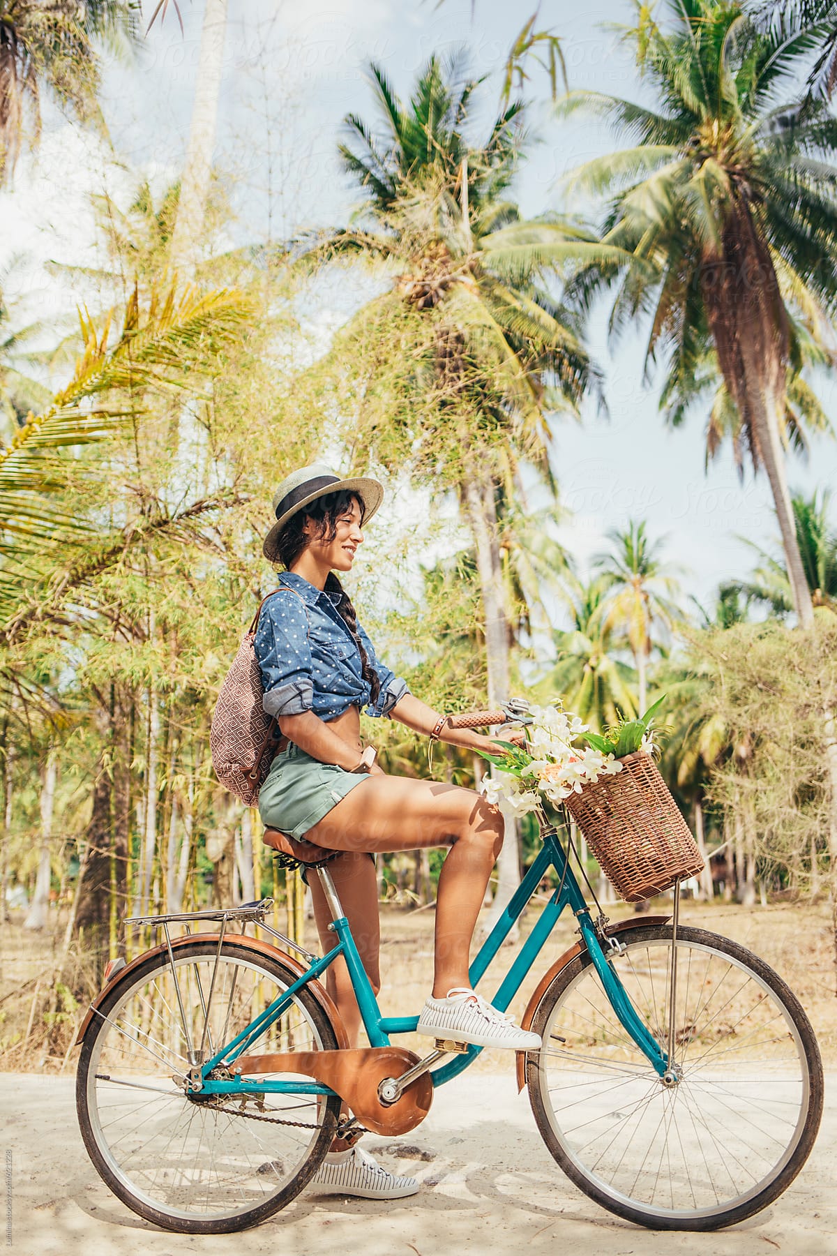 Happy Woman Riding a Bike in a Tropical Setting