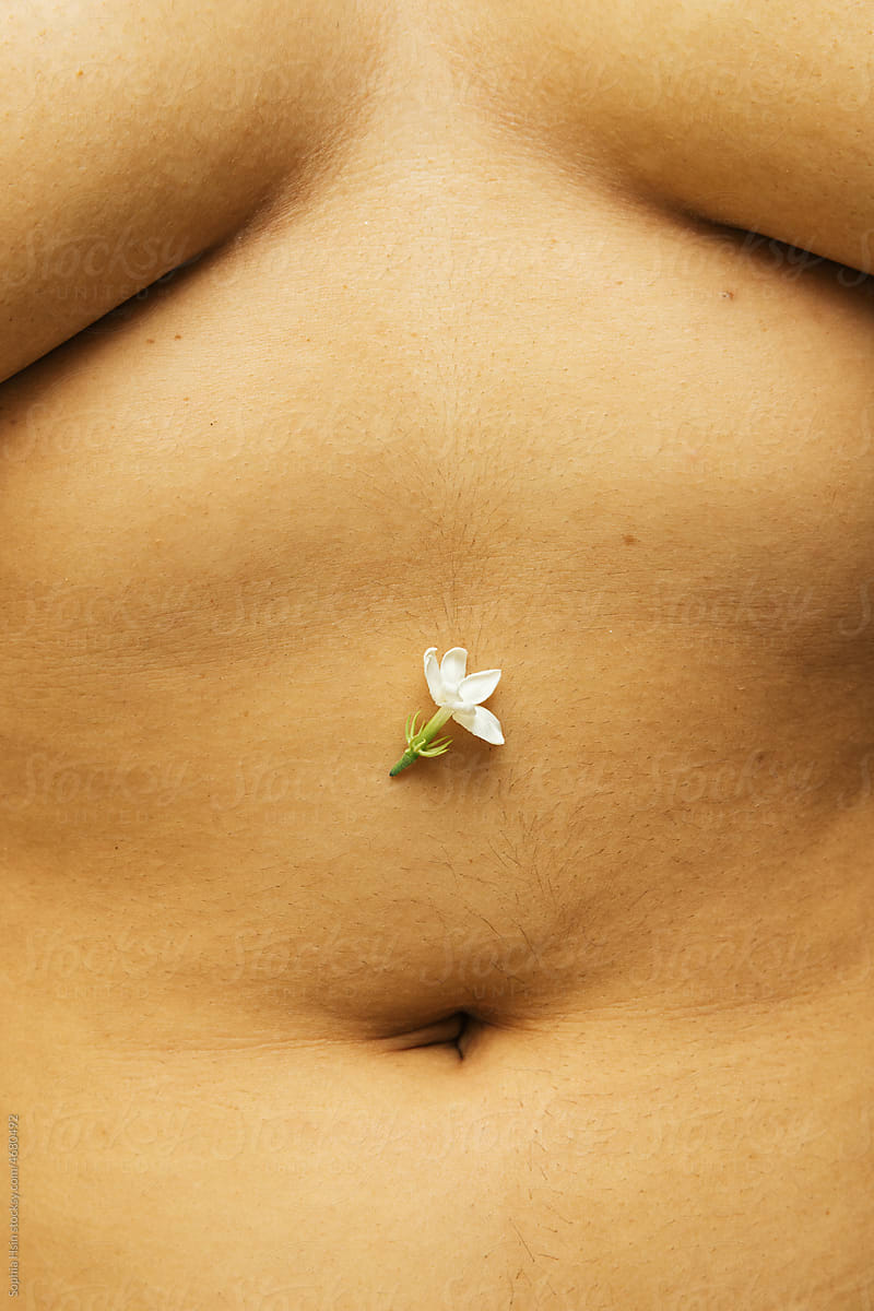 Single jasmine flower next to belly button