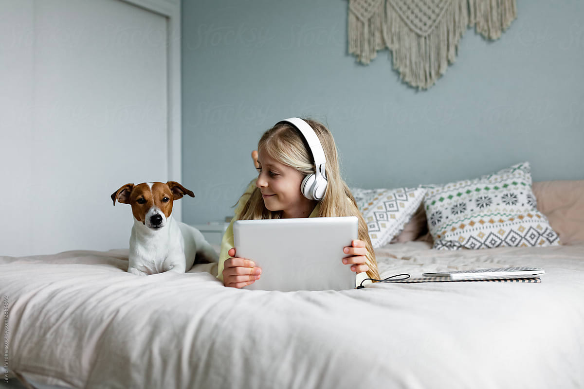 Child using tablet with dog