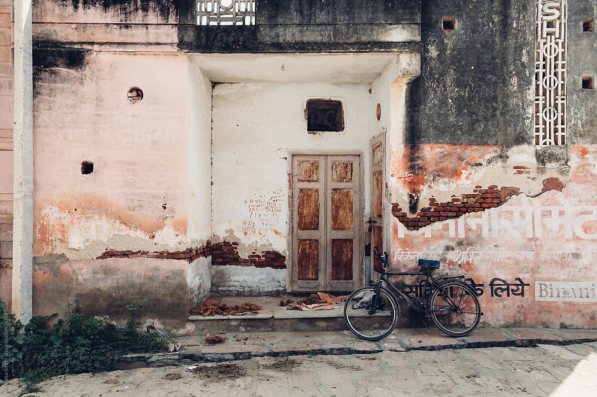 Old bicycle leaning on a rustic wall next to a doorway