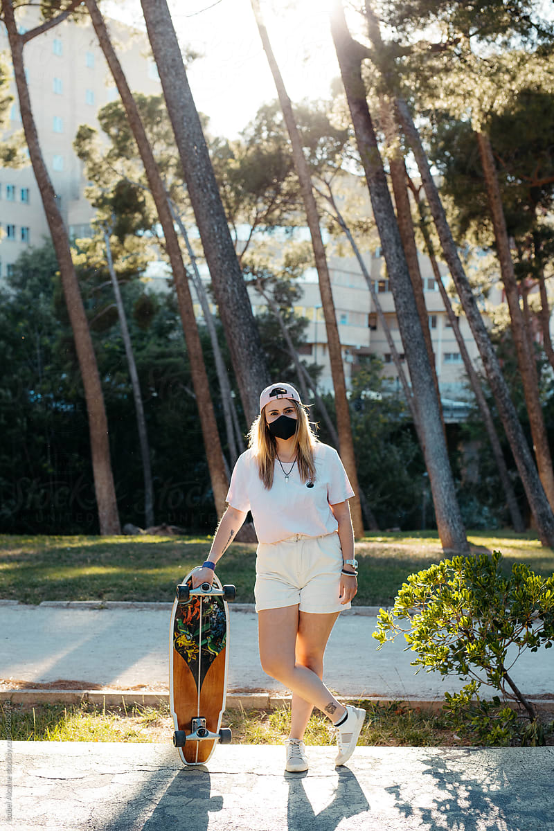 Curvy blonde skate girl with cap and mask to prevent coronavirus
