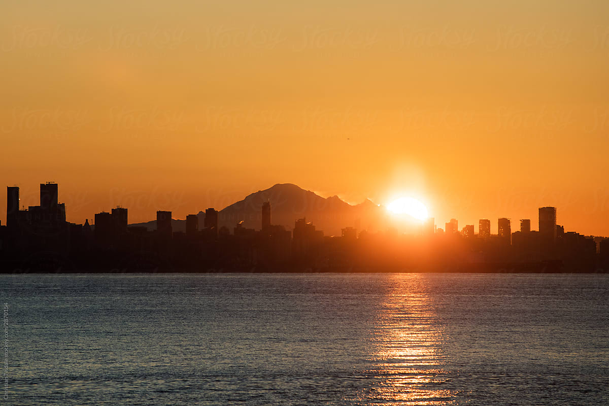 The sun rising behind Vancouver and Mount Baker