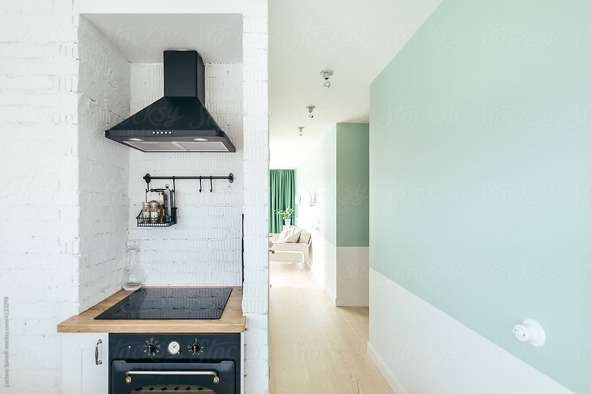 Kitchen with oven, range hood and pastel green corridor