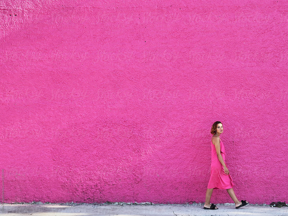 Woman in colorful dress near wall