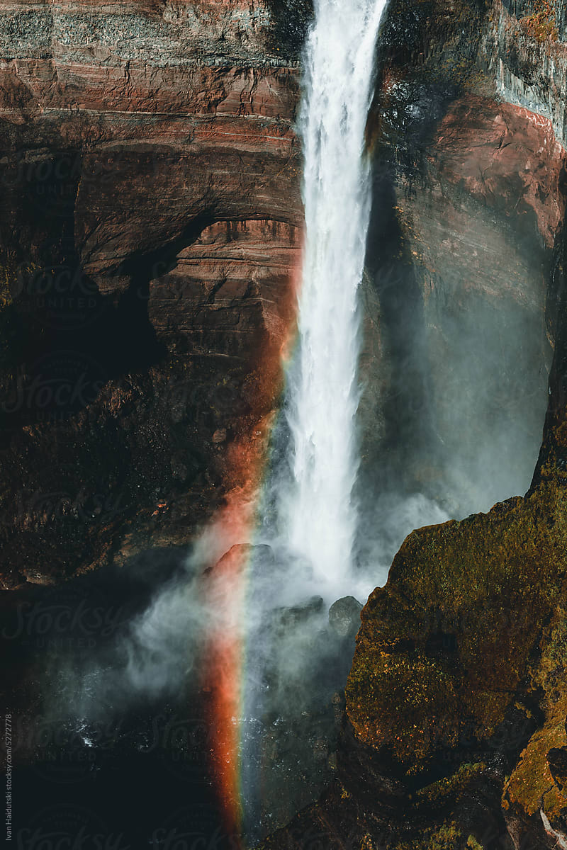 waterfall on cliff and rainbow