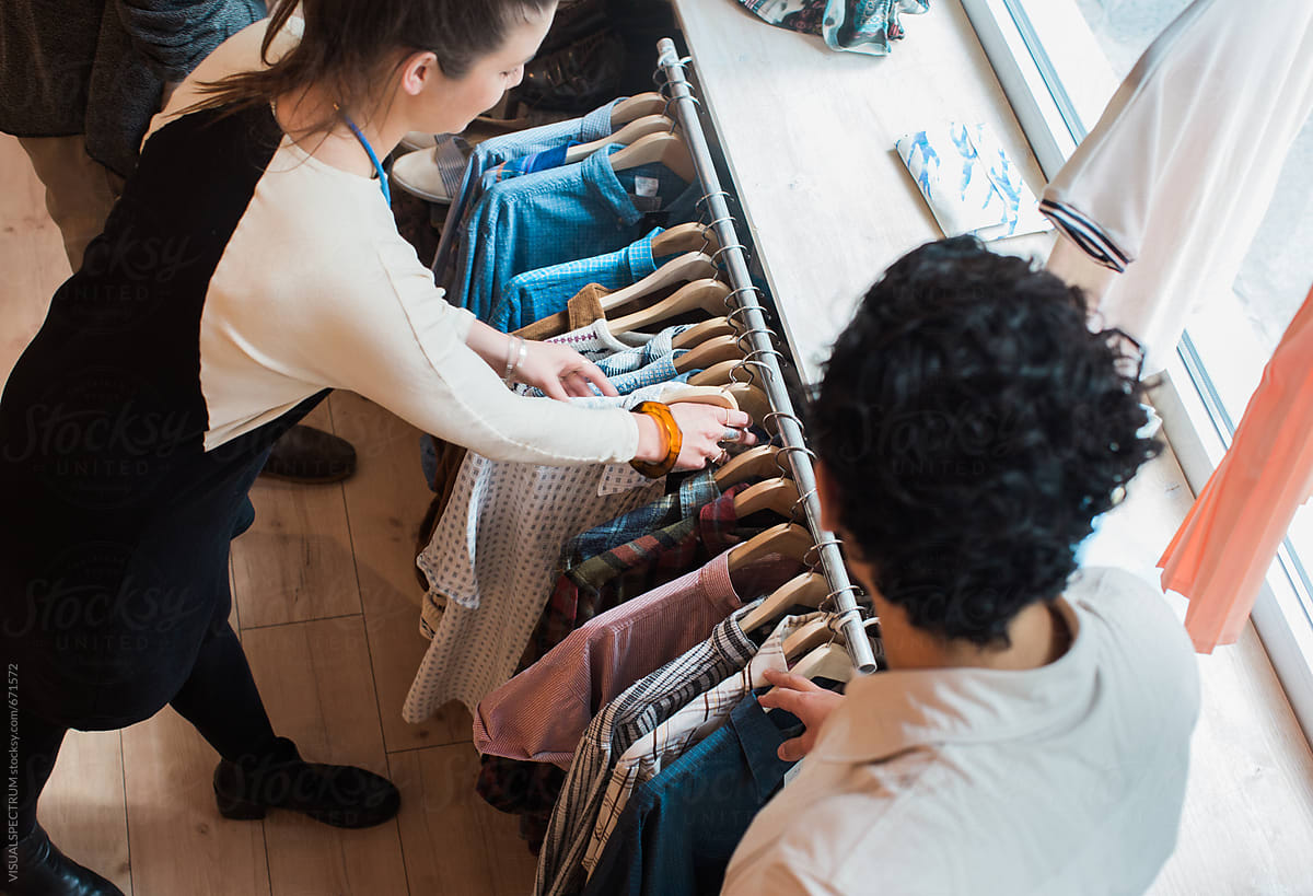 Shopping - Female Shop Assistant Arranging Shirts on Clothing Rack