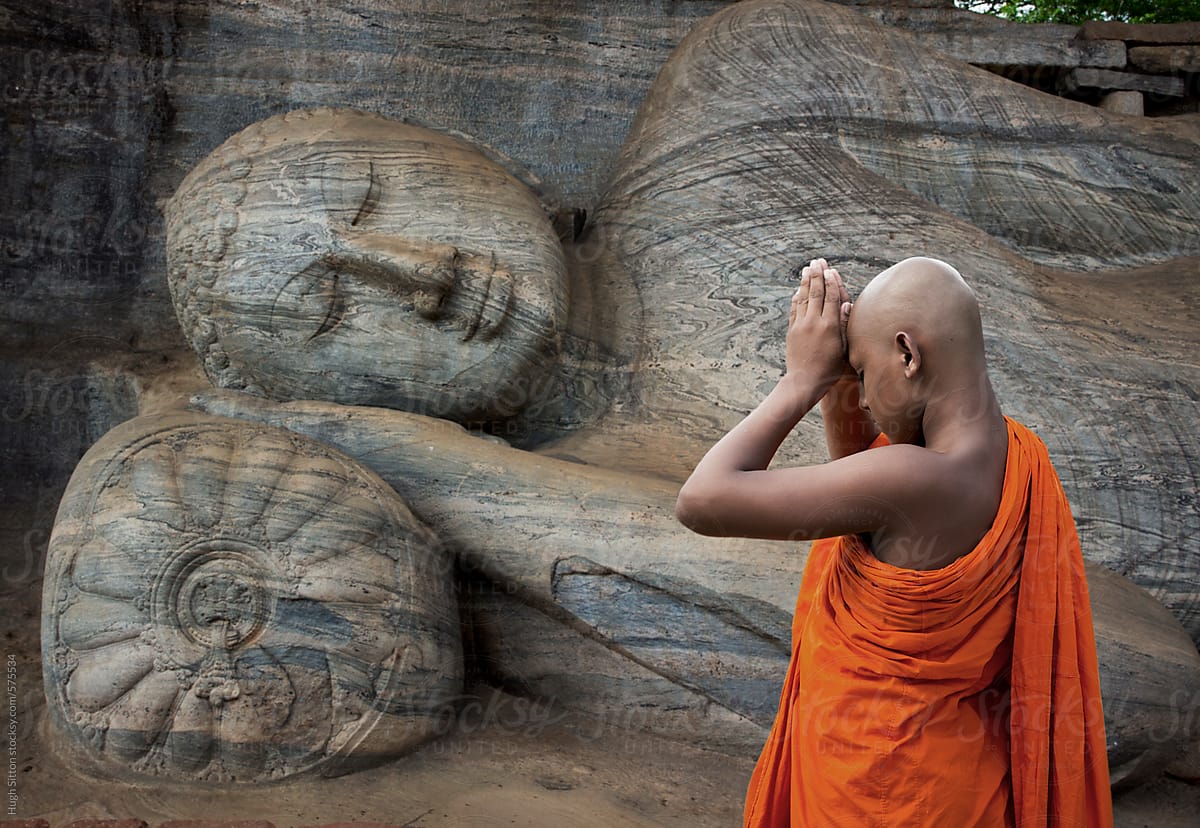 Buddhist Monk Praying At The Reclining Buddha. Polonnaruwa. Sri Lanka