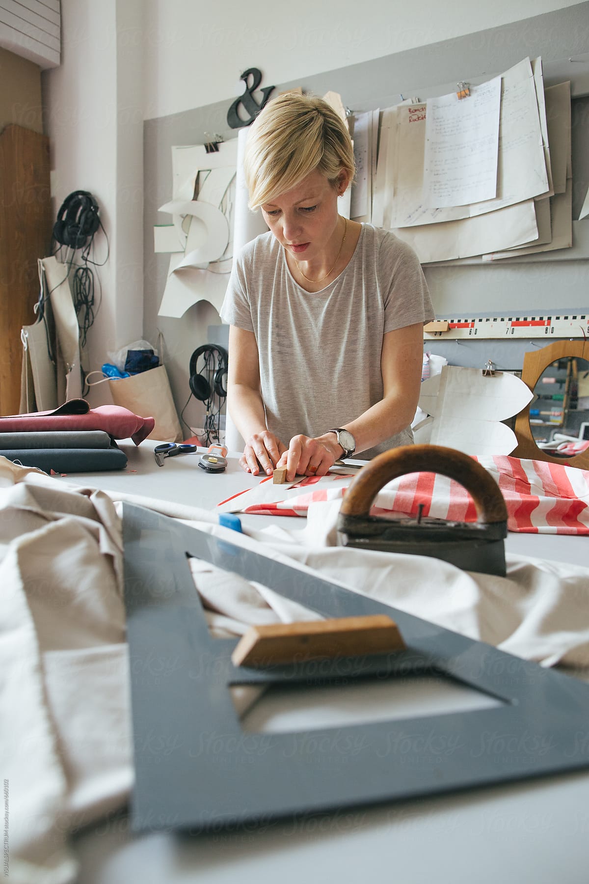 Blond Woman Preparing to Cut Fabric in Bright Dressmaking Atelier