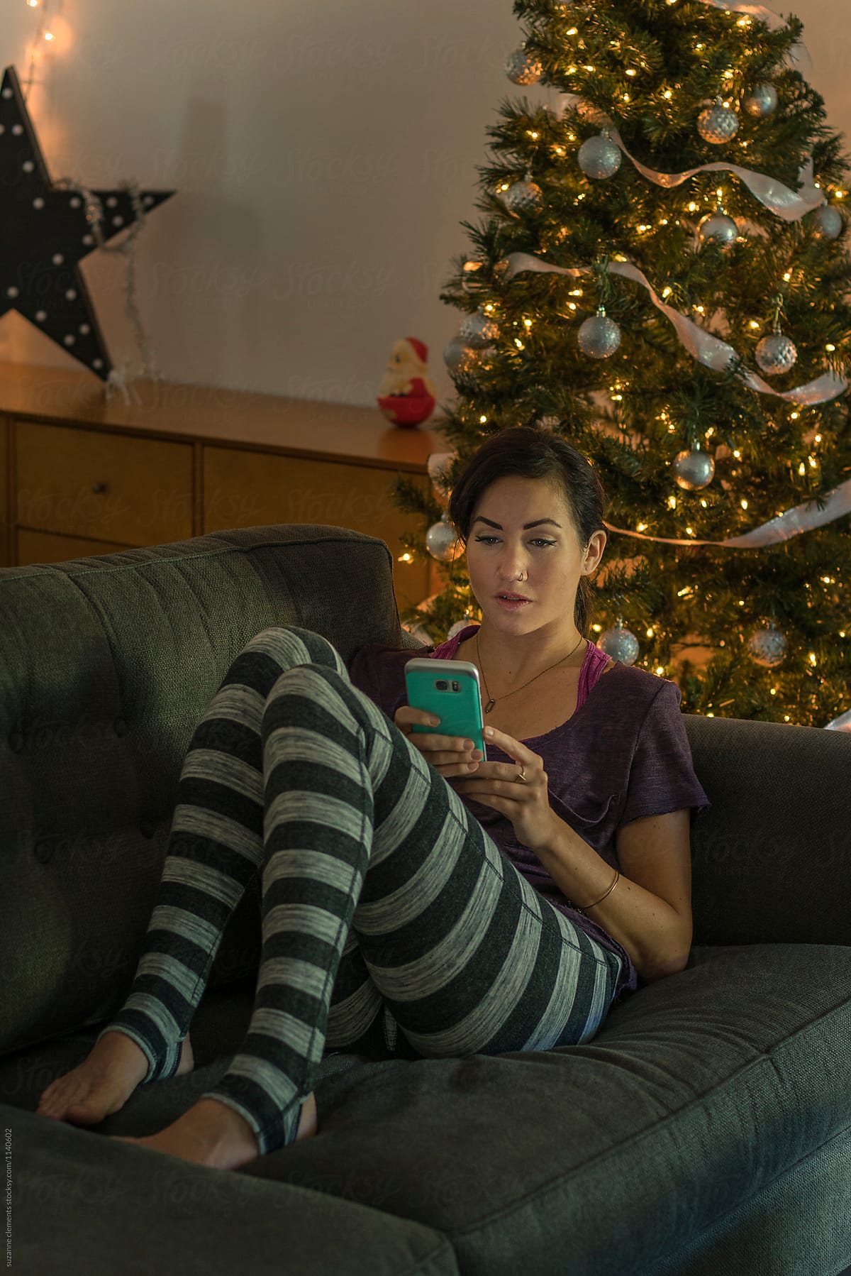Woman Relaxing by her Christmas Tree at the Holidays