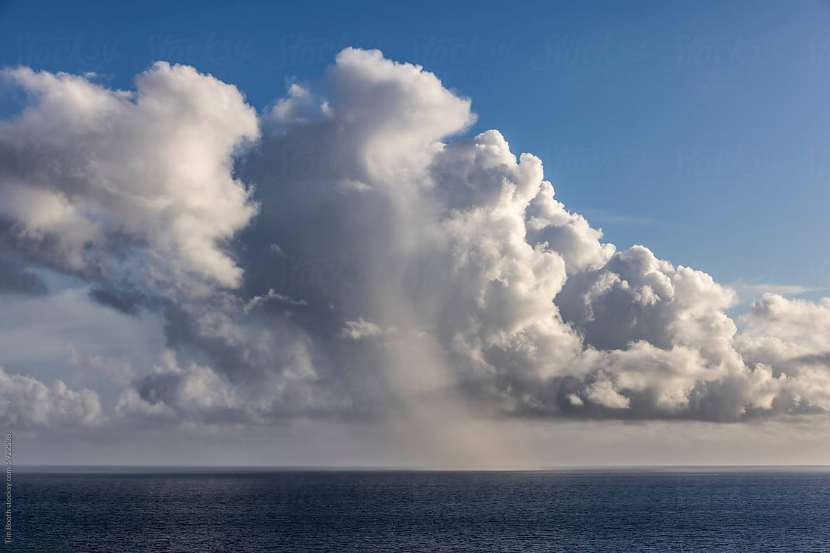 A cloud dropping rain over the sea.