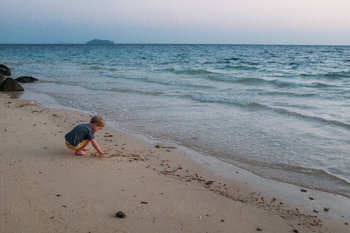 Young child at sunrise on a tropical beach