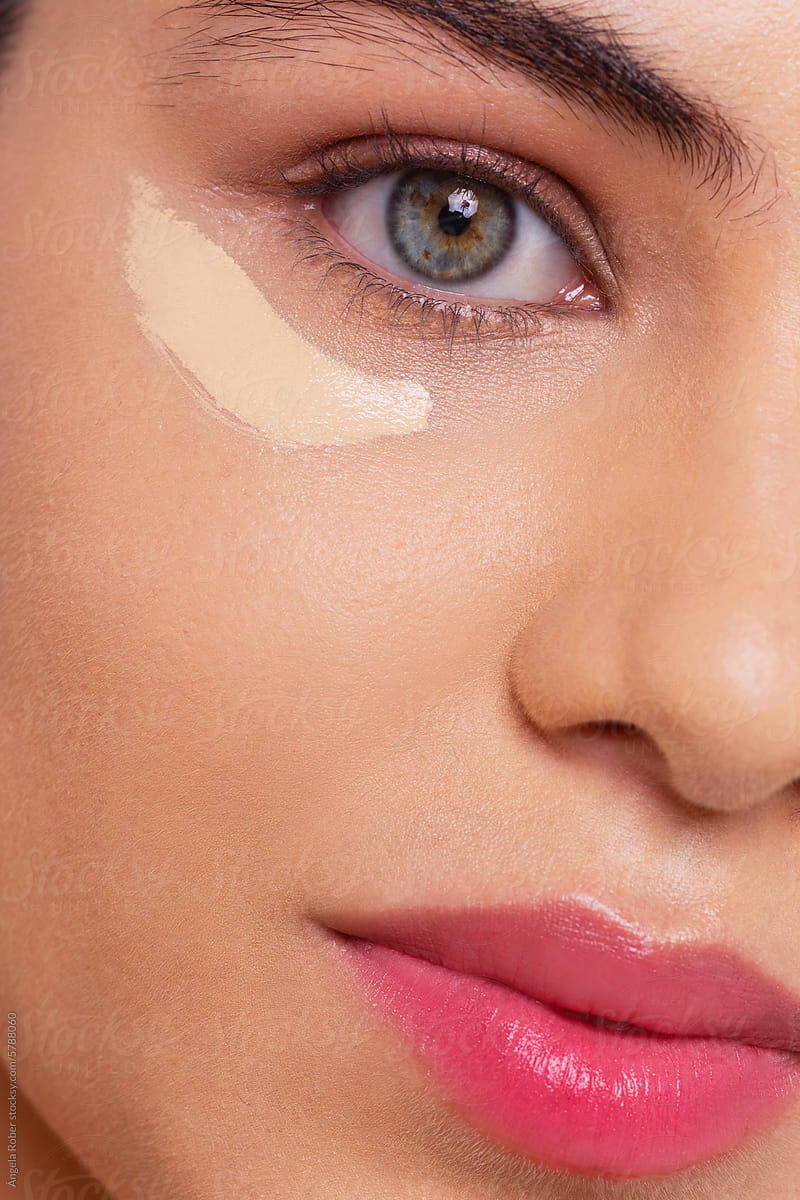 Closeup of a woman with a swatch of concealer under her eye
