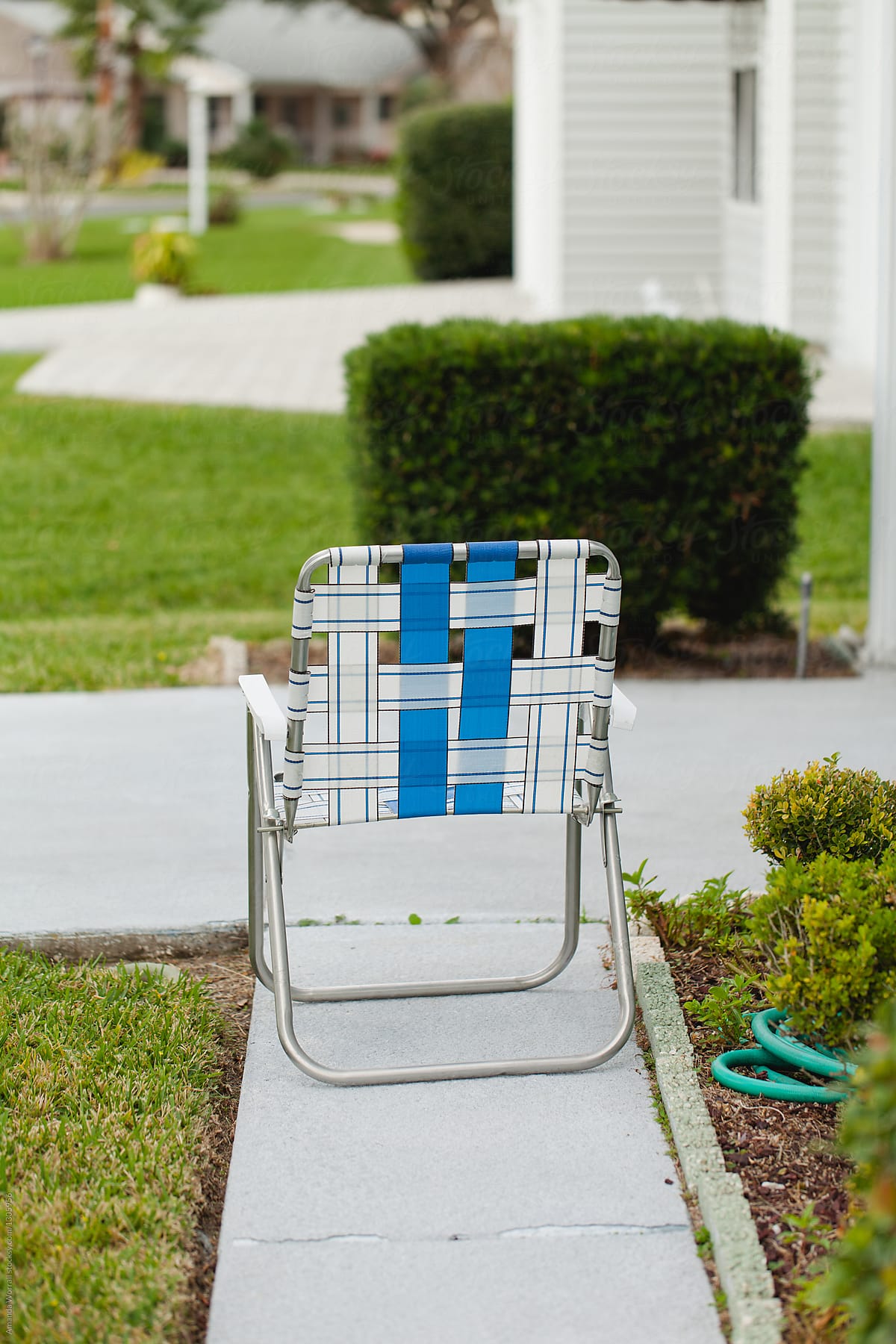 Lawn Chair on sidewalk in front of a home