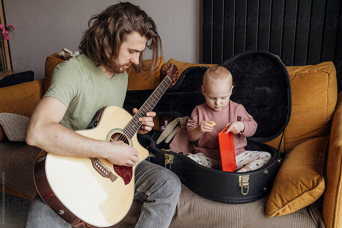 Daughter Playing Near Father With Guitar