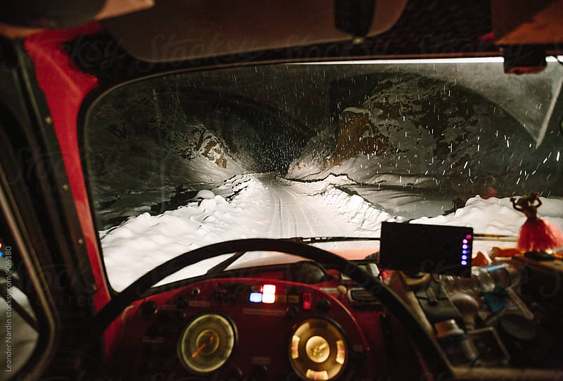 snowstorm on a remote snowcovered mountain road seen from inside a truck