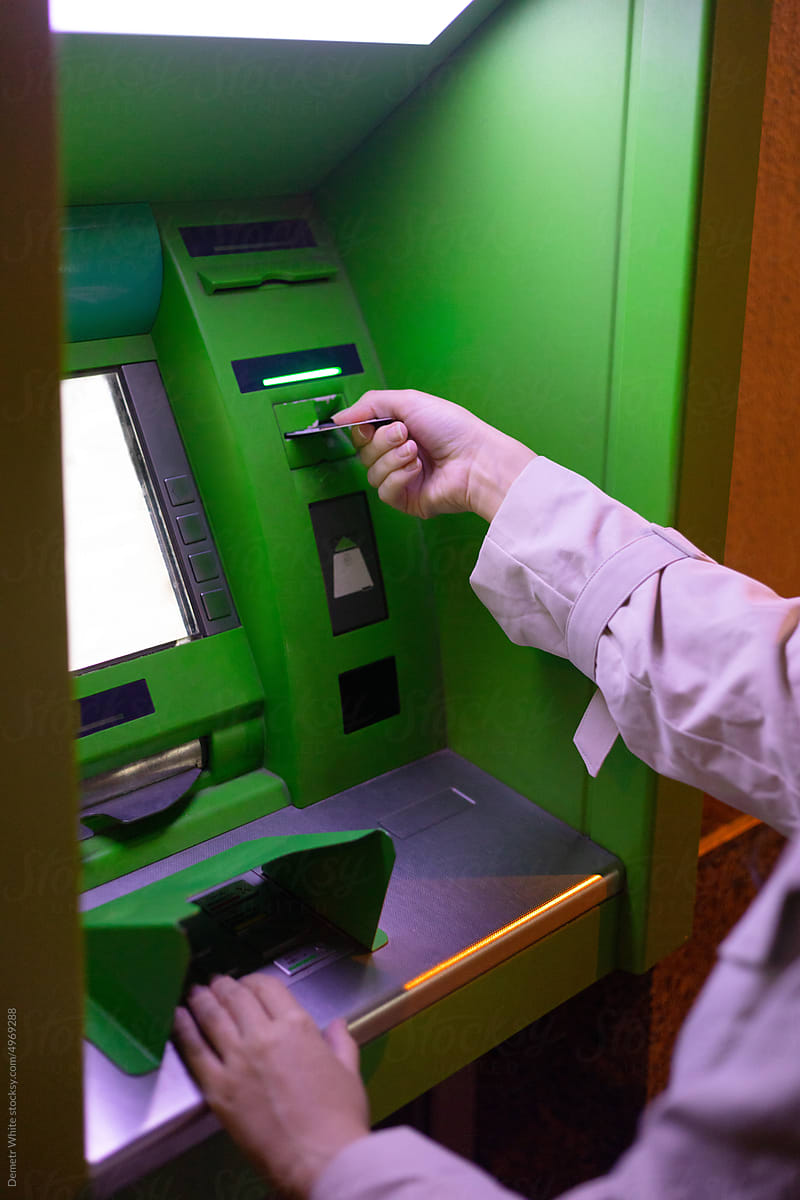 woman's hands in the process of interacting with an ATM