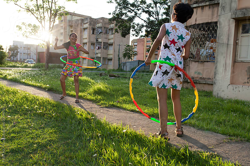 Two teenage girls playing and making fun with Hula Hoop