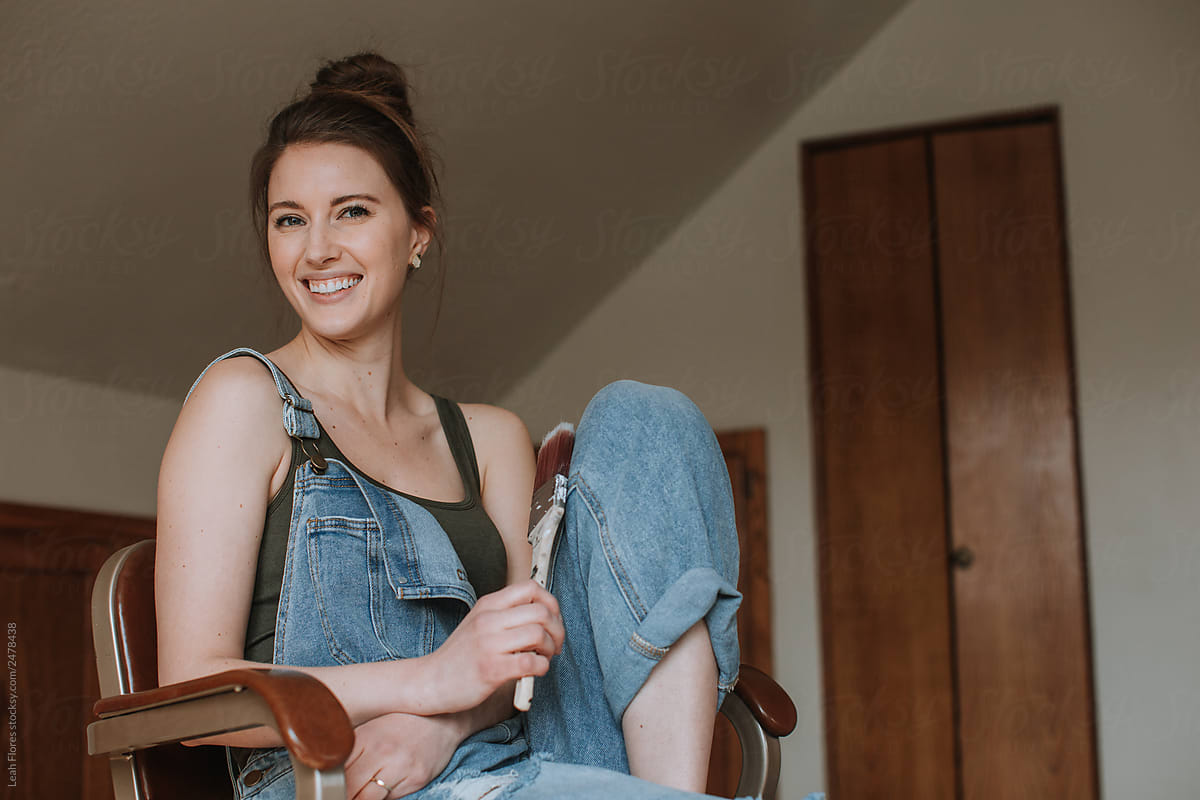 Woman Sitting, Smiling Holding Paintbrush