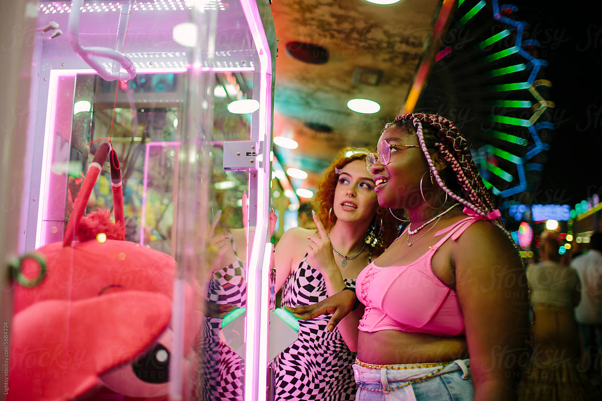 Young women playing at a fun fair at night