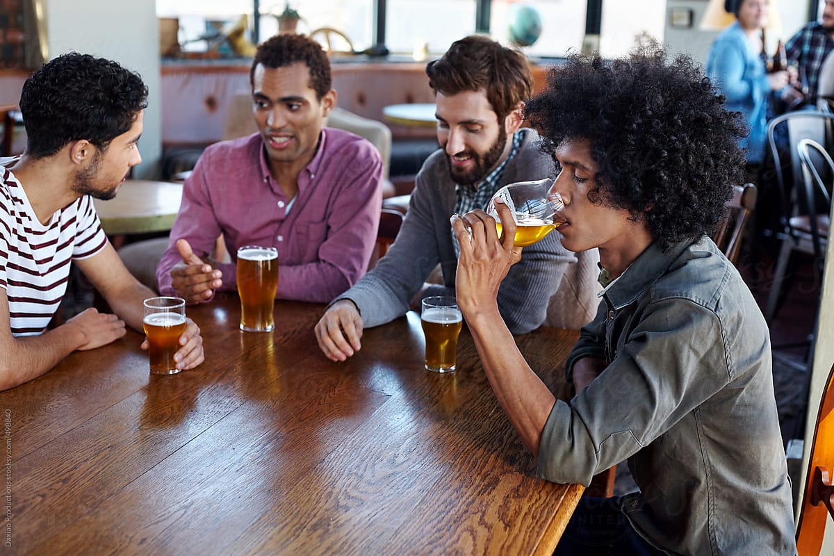 Friends relaxing at a table with beers in a restaurant bar
