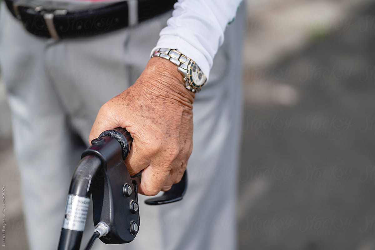 Older adult\'s hand attached to handlebars