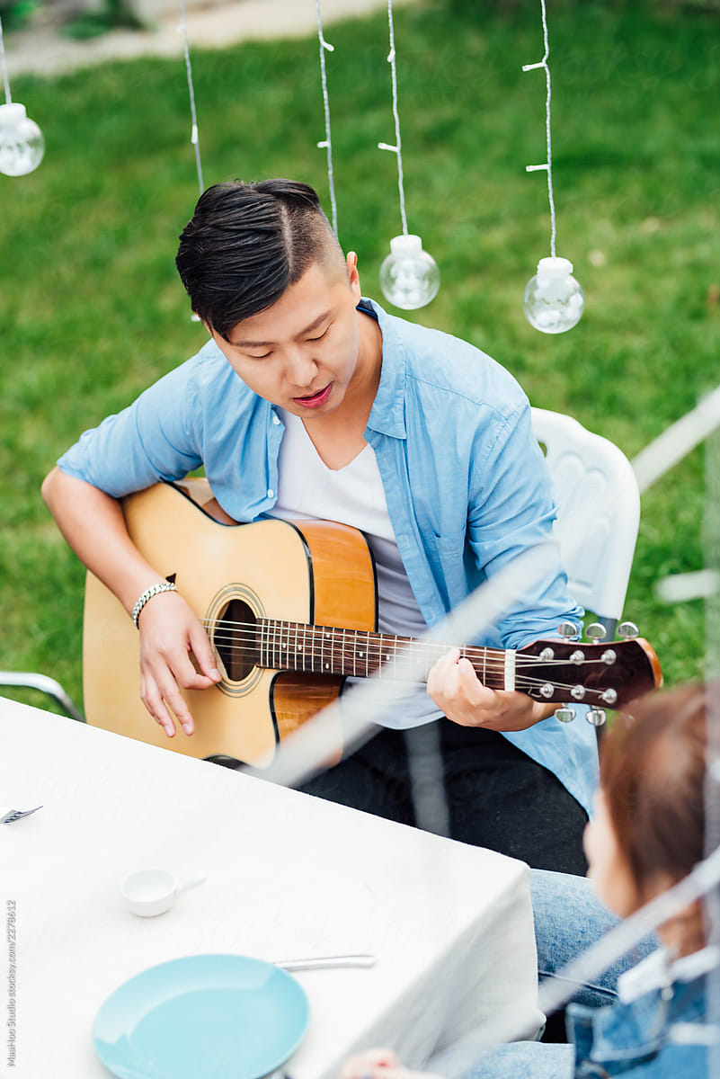 Young man playing guitar outdoors