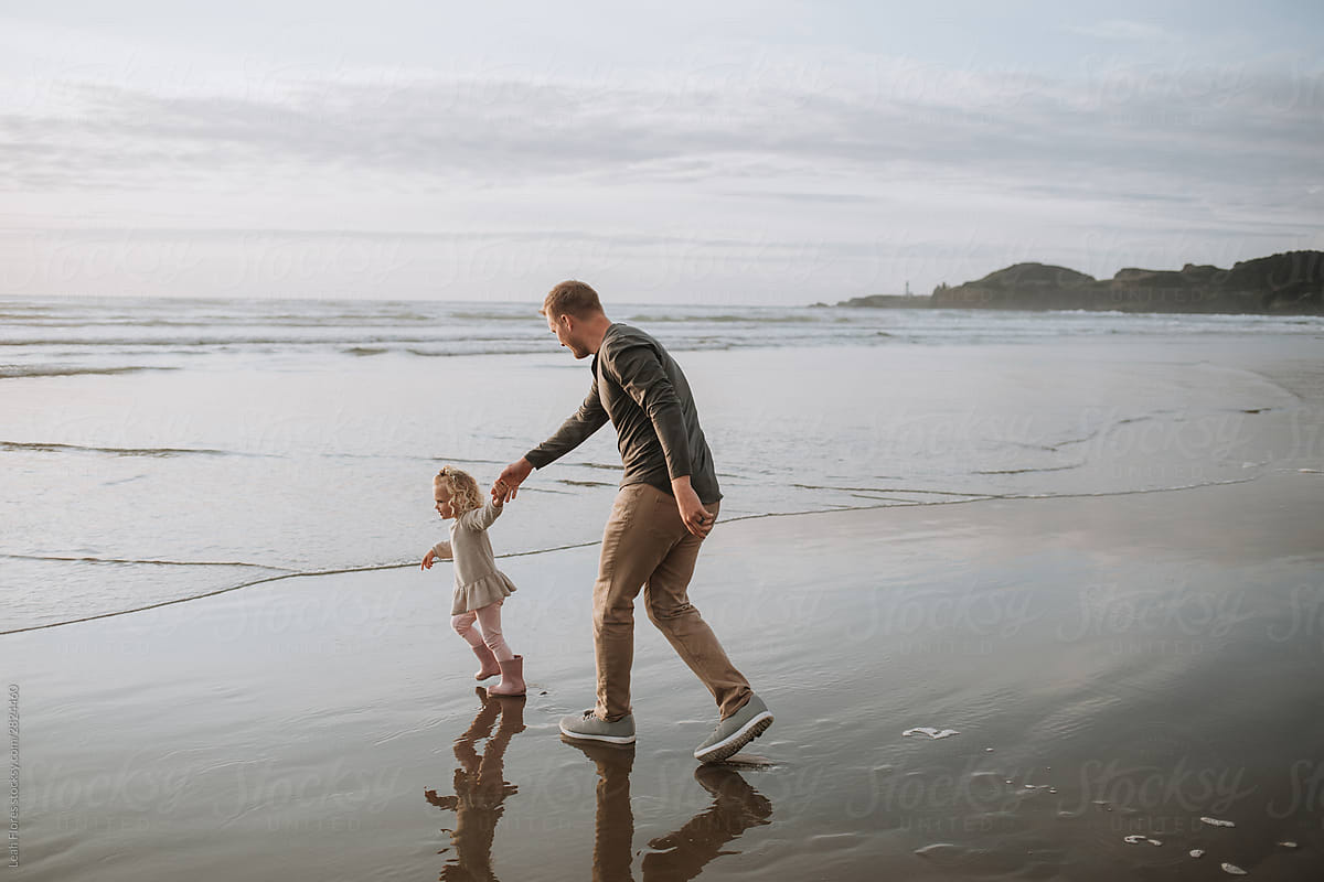 Father and Young Daughter Walking on Beach