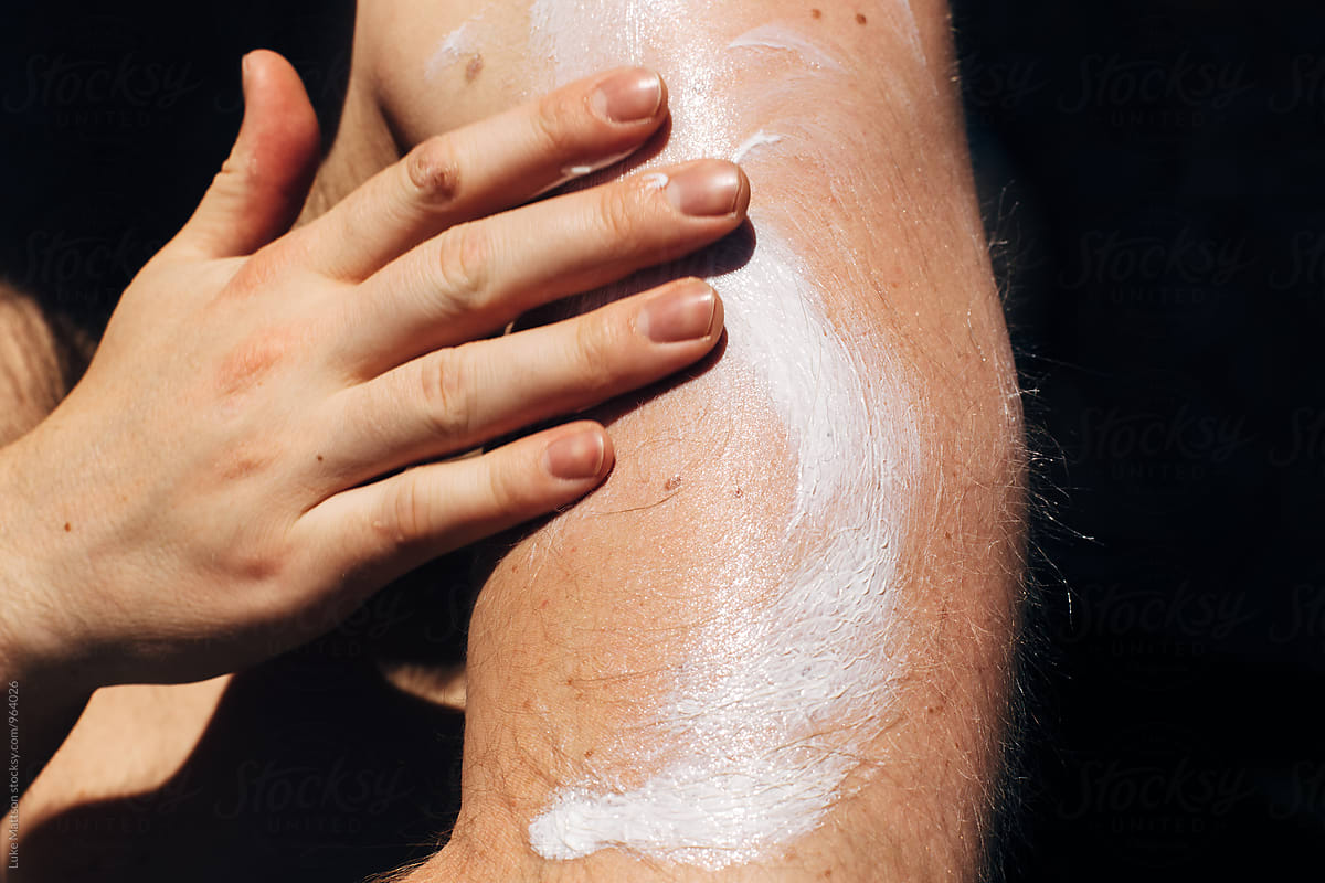 Man Applying Sunscreen Lotion To Bicep Of Hairy Arm