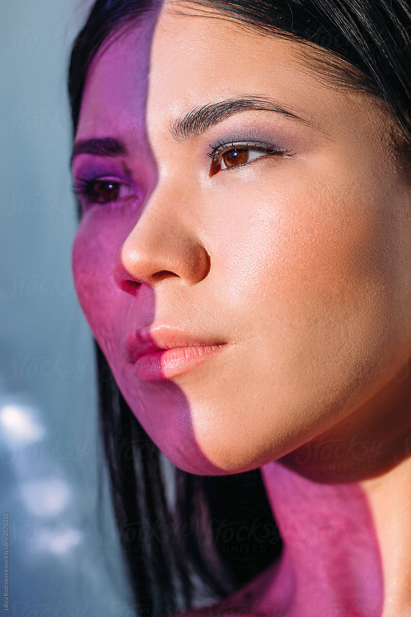 Beauty portrait of asian woman with half-face covered with purple shadow