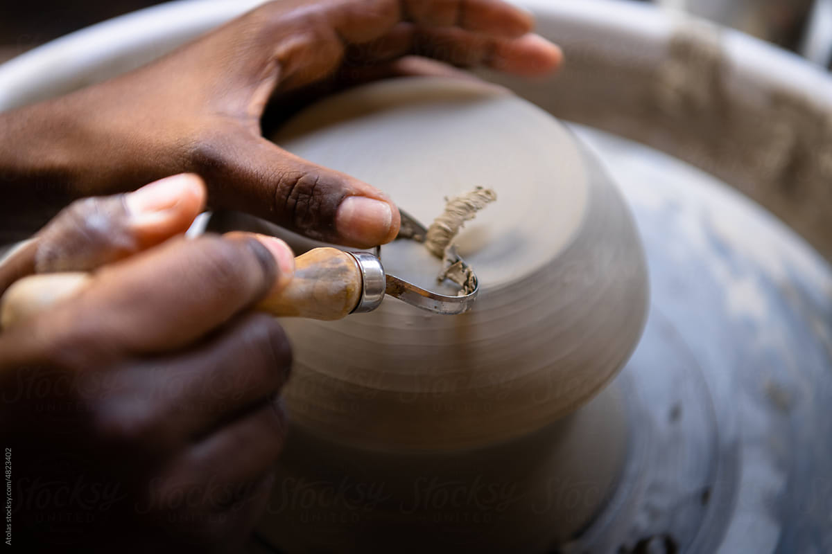 Closeup of woman shaping clay edges on pottery wheel