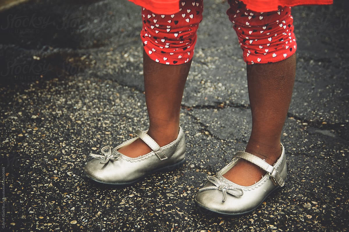 African American girl\'s feet wearing silver shinning shoes